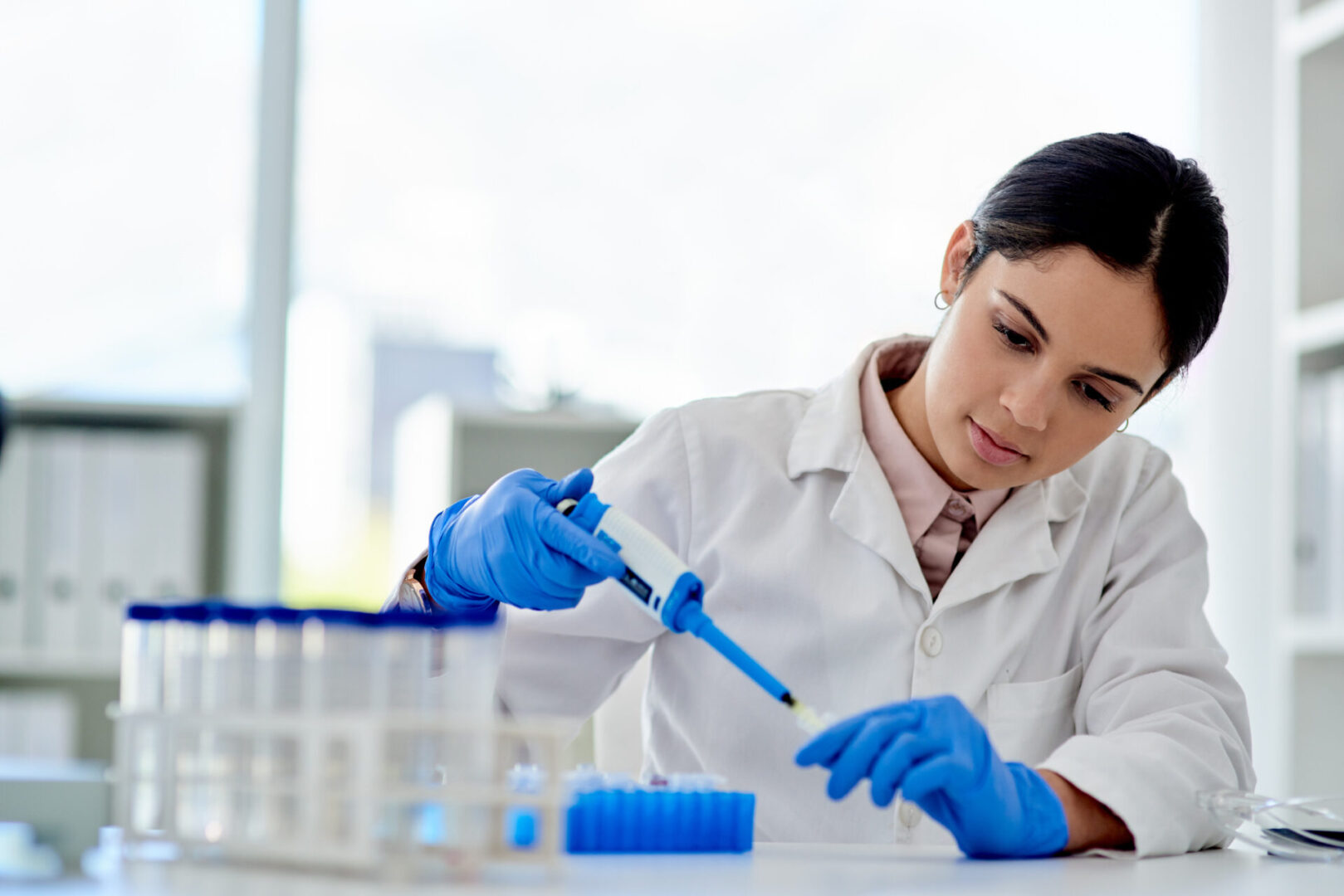 Scientist in a lab using a pipette for experiments.