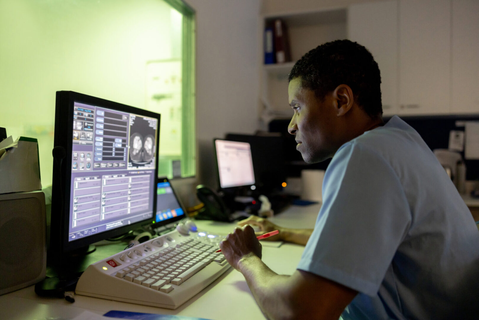 Man working on computer with complex data on screen.