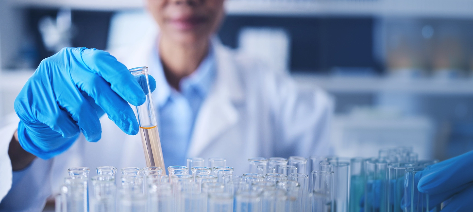 Scientist handling test tubes in a laboratory setting.